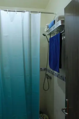a bathroom with a shower with a blue shower curtain at beautiful appartement near airport in Marrakech