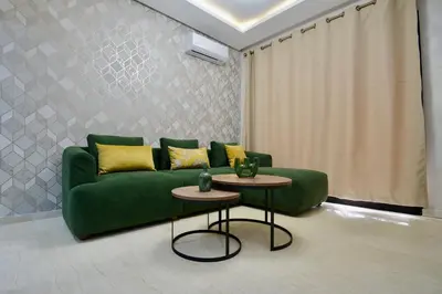 a living room with a green couch and two tables at Marrakesh Cozy Desert Oasis in Marrakech
