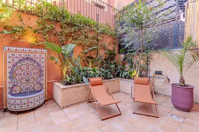 a patio with two chairs and some plants at Duplex Le Majorelle, Res devant le jardin, piscine in Marrakech