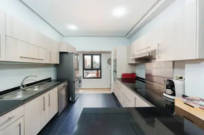 a kitchen with white cabinets and a black floor at Exclusive Stay M-Avenue Marrakech in Marrakech