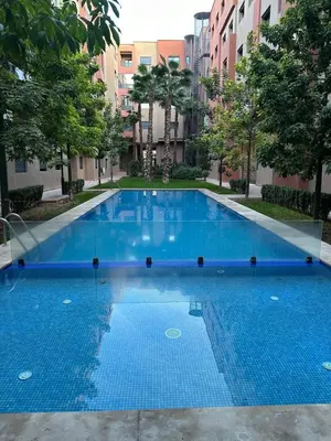 a large blue swimming pool in a building at La Citrine appartement de haut standing in Marrakech