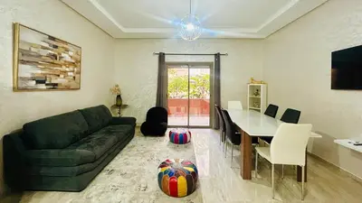a living room with a couch and a table at le saphir un appartement de paradis in Marrakech