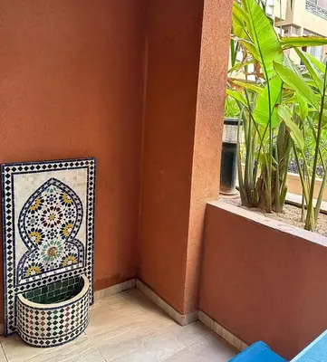 a mosaic bench sitting next to a wall with a window at le saphir un appartement de paradis in Marrakech