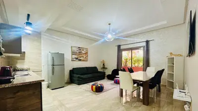 a kitchen and a living room with a table at le saphir un appartement de paradis in Marrakech