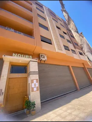 a building with two garage doors and a basketball hoop at Appart26 Marrakech guéliz en face la Gare in Marrakech