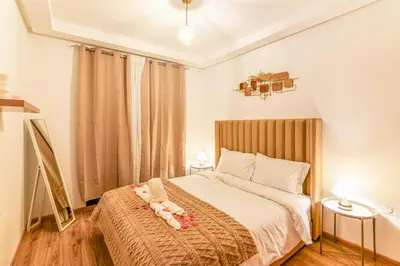 a bedroom with a large bed with white sheets at Mya cosy - Clim, Wifi, Jardin à 10min de l'Aéroport in Marrakech