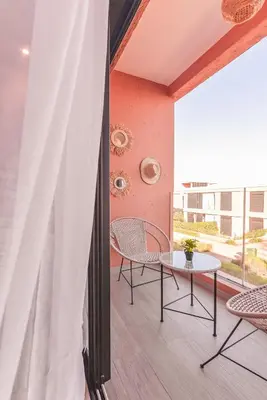 a balcony with a table and chairs and a window at Mya cosy - Clim, Wifi, Jardin à 10min de l'Aéroport in Marrakech