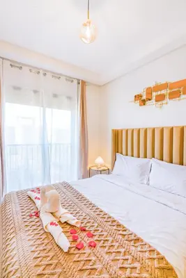 a bedroom with a bed with towels on it at Mya cosy - Clim, Wifi, Jardin à 10min de l'Aéroport in Marrakech