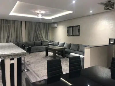 a living room with a couch and a table at Modern apartment centre ville in Marrakech