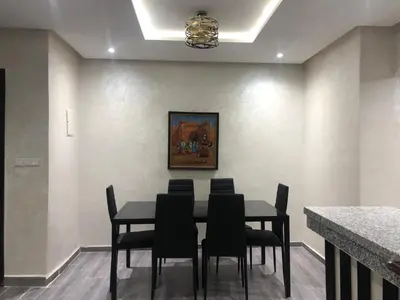 a dining room with a black table and chairs at Modern apartment centre ville in Marrakech