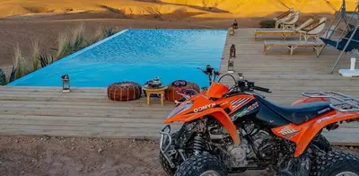 an orange dirt bike parked on a deck next to a pool at Marrakech appartement in Marrakech
