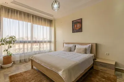 a bedroom with a bed and a large window at Elegant apartment downtown in Marrakech