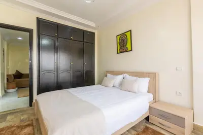 a bedroom with a white bed and a mirror at Elegant apartment downtown in Marrakech