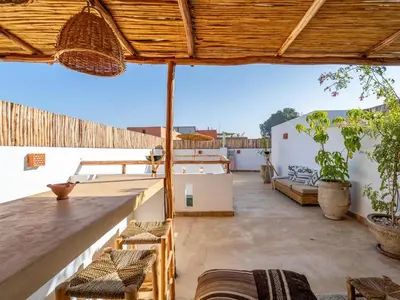 an outdoor patio with chairs and an umbrella at Riad Dar Victoire in Marrakech