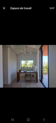 a dining room with a table and a window at Magnifique appartement in Marrakech