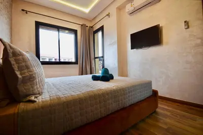 a bedroom with a teddy bear sitting on a bed at Serenity City Center Apt in Marrakech