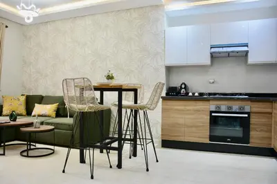 a kitchen and living room with a table and chairs at Serenity City Center Apt in Marrakech