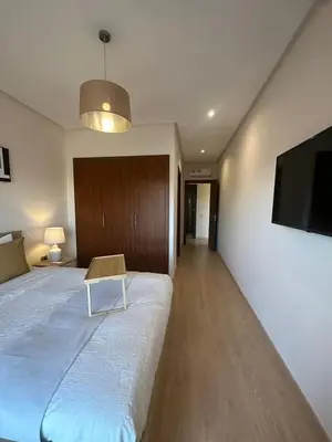 a bedroom with a bed and a tv on a wall at apartment sur GOLF prestigia avec piscine in Marrakech
