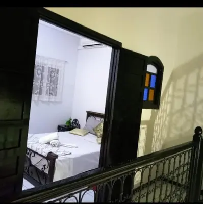 a bedroom with a bed and a balcony with a window at LOGEMENT ENTIER MARRAKECh G1 - N3 in Marrakech