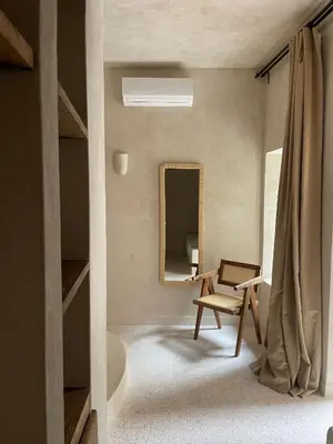 a living room with a chair and a mirror at Riad Roca in Marrakech