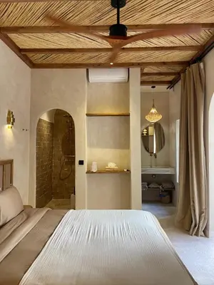 a bedroom with a large bed with a wooden ceiling at Riad Roca in Marrakech