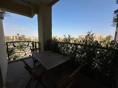 a porch with a table and chairs on a balcony at Duplex à l hivernage in Marrakech