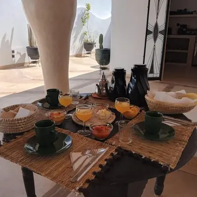 a table with glasses of orange juice on it at Riad Le Jardin des Matières in Marrakech