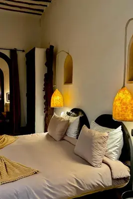 a bedroom with a bed with two lamps on it at Riad Le Jardin des Matières in Marrakech