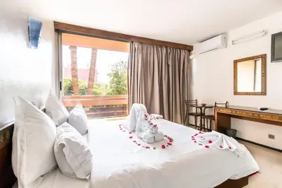 a bedroom with a large white bed with white pillows at Hotel Le Grand Imilchil in Marrakech