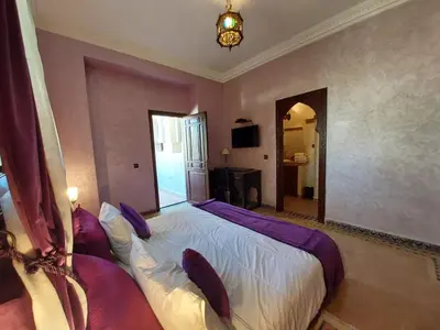 a bedroom with a large bed with purple pillows at Jasmin d'Atlas in Marrakech