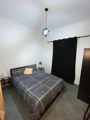 a bedroom with a bed and a black curtain at Appartement au Cœur de Guéliz in Marrakech