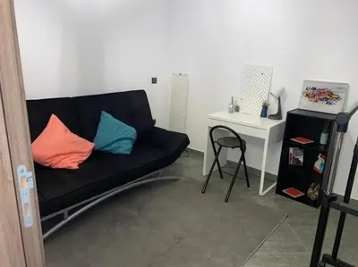 a living room with a black couch with two pillows at Appartement au Cœur de Guéliz in Marrakech