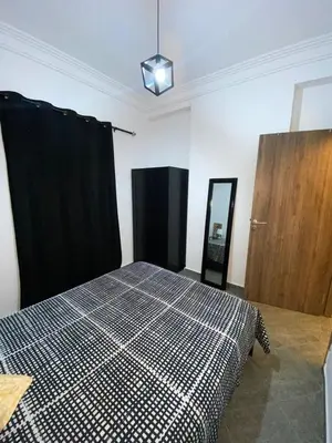 a bedroom with a bed with a checkered blanket at Appartement au Cœur de Guéliz in Marrakech