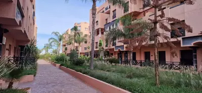 an empty street with palm trees and buildings at Havre de paix in Marrakech