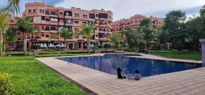 two children standing by a swimming pool in front of a building at Havre de paix in Marrakech