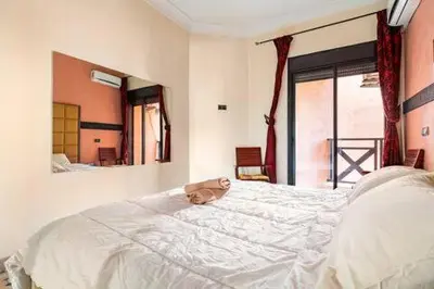 a stuffed animal laying on a white bed in a bedroom at Havre de paix in Marrakech