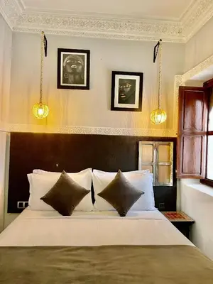 a bedroom with a large bed with two pillows at Riad Al Wafaa in Marrakech