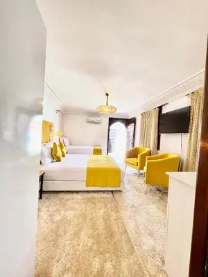 a bedroom with a bed and yellow chairs at Riad Al Wafaa in Marrakech