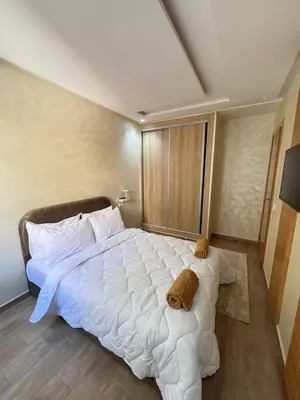 a bedroom with a large white bed with towels on it at Calm apartment 10 min from Majorelle Garden in Marrakech
