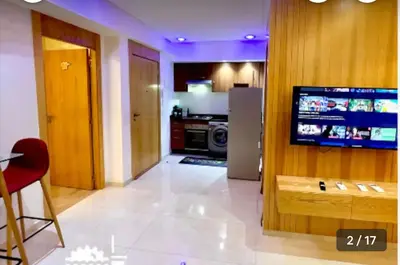 a living room with a television and a kitchen at Calm apartment 10 min from Majorelle Garden in Marrakech