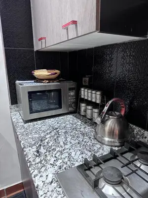 a kitchen with a microwave and a tea kettle on a stove at RENTSUITE APPARTEMENT Premium Village Luxurious Residence in Marrakech