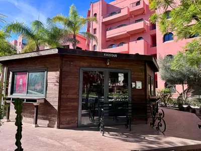 a small building in front of a pink building at RENTSUITE APPARTEMENT Premium Village Luxurious Residence in Marrakech