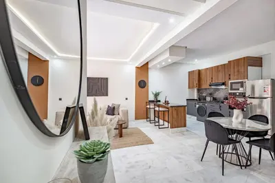 a kitchen and living room with a table and chairs at Serenite tranquille au coeur du centre ville in Marrakech