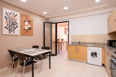 a kitchen with a table and chairs in a room at Appart Hyper-Centre Gueliz - Wifi - Netflix in Marrakech