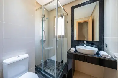 a bathroom with a sink and a toilet and a mirror at Apart Confort Rez-de-Jardin Piscine Wi-Fi Terrasse in Marrakech