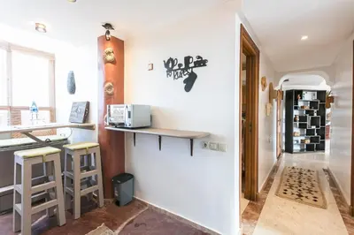 a kitchen with a counter and stools in a room at Le Joyau De Majorelle - Marrakech in Marrakech
