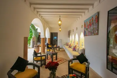 a living room with chairs and a couch and a table at Riad Tampacao in Marrakech