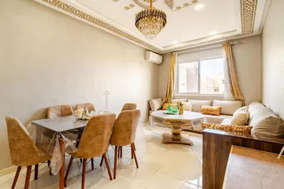 a living room with a table and chairs and a couch at luxury appartement near gueliz voyageurs in Marrakech