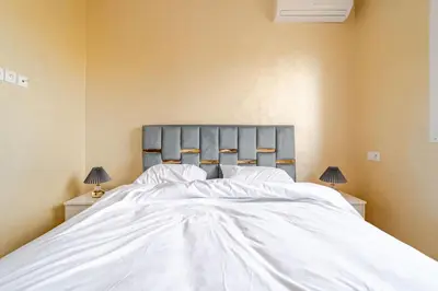 a bedroom with a large white bed with two lamps at luxury appartement near gueliz voyageurs in Marrakech