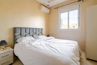 a bedroom with a large white bed with a window at luxury appartement near gueliz voyageurs in Marrakech